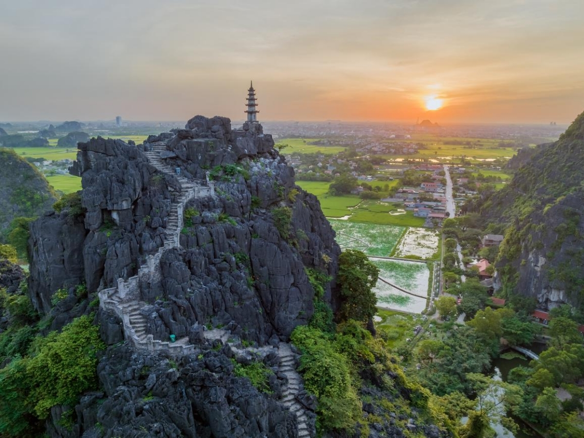 Hang Múa tọa lạc trên núi đá mang vẻ đẹp huyền ảo dưới ánh hoàng hôn.