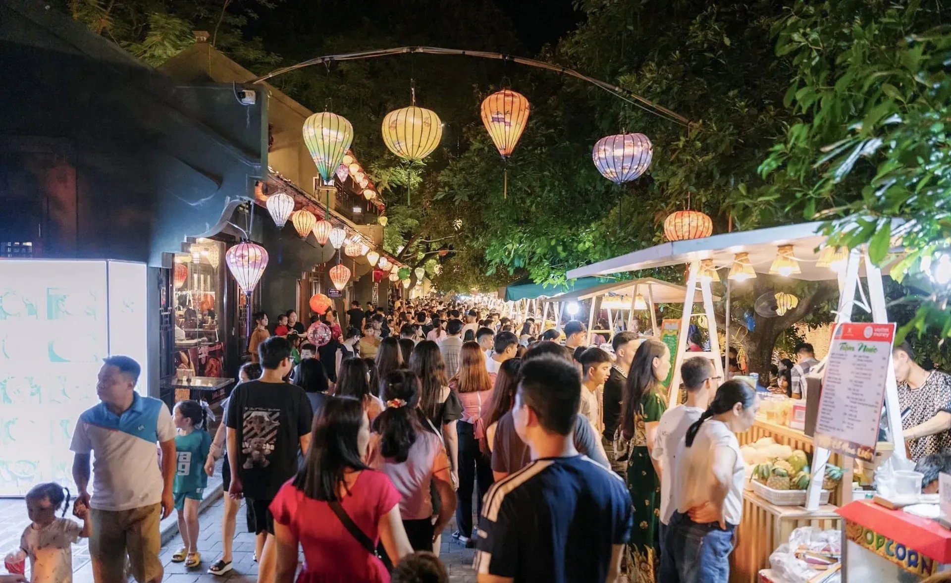 Khung cảnh Tam Cốc về đêm với phố du lịch nhộn nhịp, ánh đèn lồng lung linh.