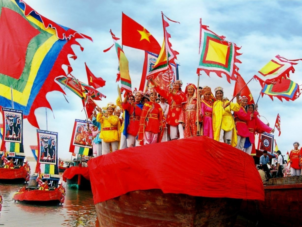 Đoàn người trong trang phục truyền thống rực rỡ tham gia lễ hội trên sông.