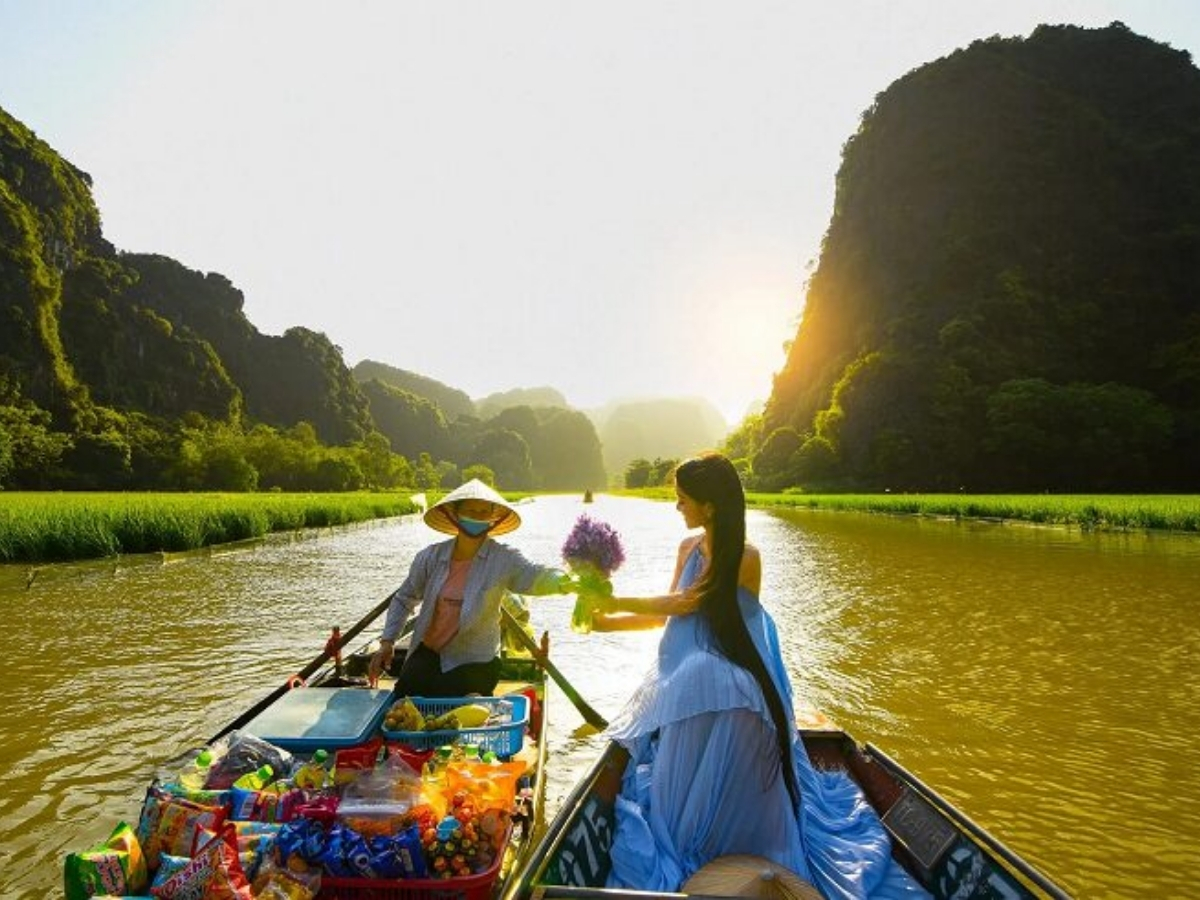 Du khách ngồi thuyền đến Tam Cốc và trải nghiệm mua hoa thú vị. (Nguồn: Sưu tầm)
