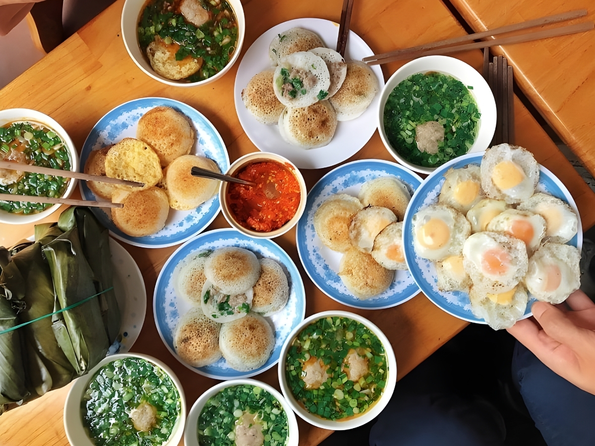 Bàn ăn bày nhiều đĩa bánh cơm cháy đặc sản Ninh Bình.