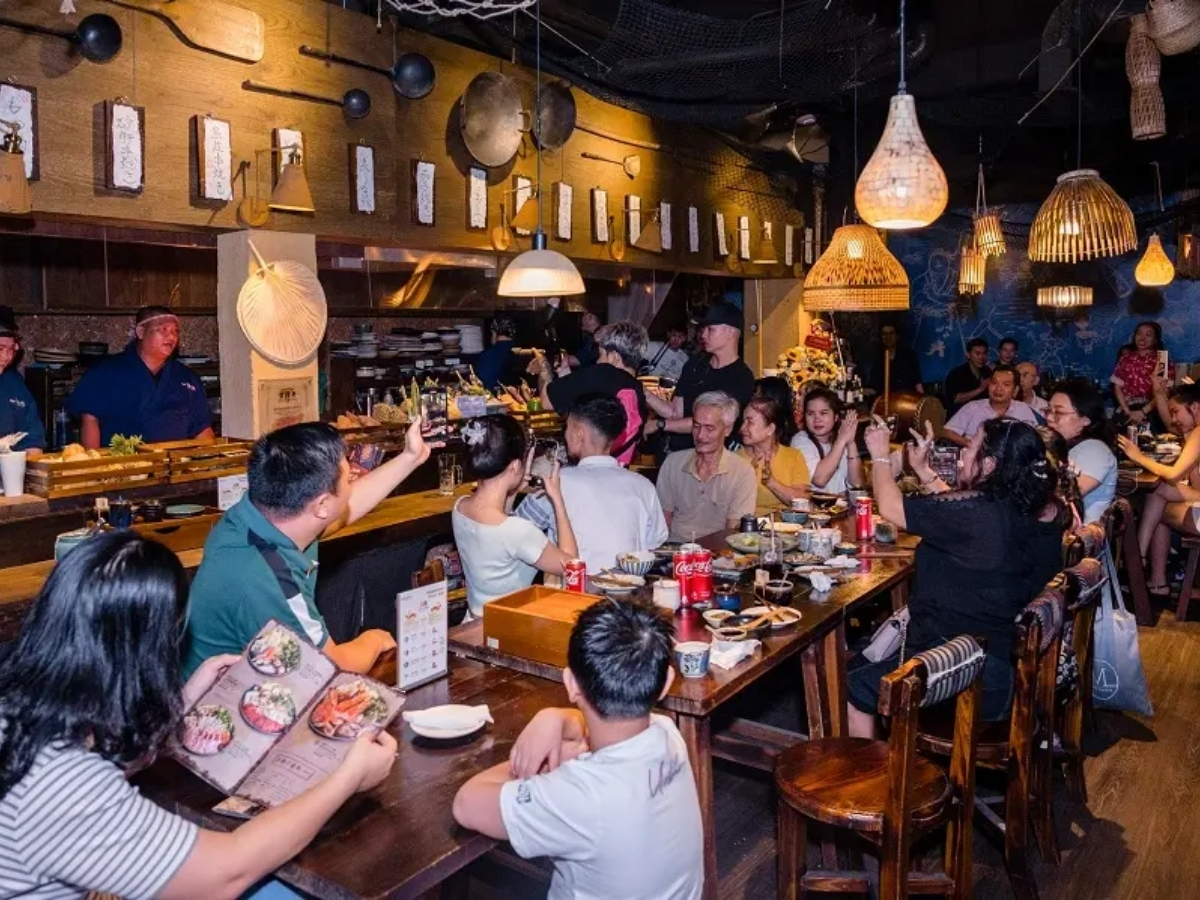 Không gian quán ăn ấm cúng và du khách thưởng thức ẩm thực sôi nổi.
