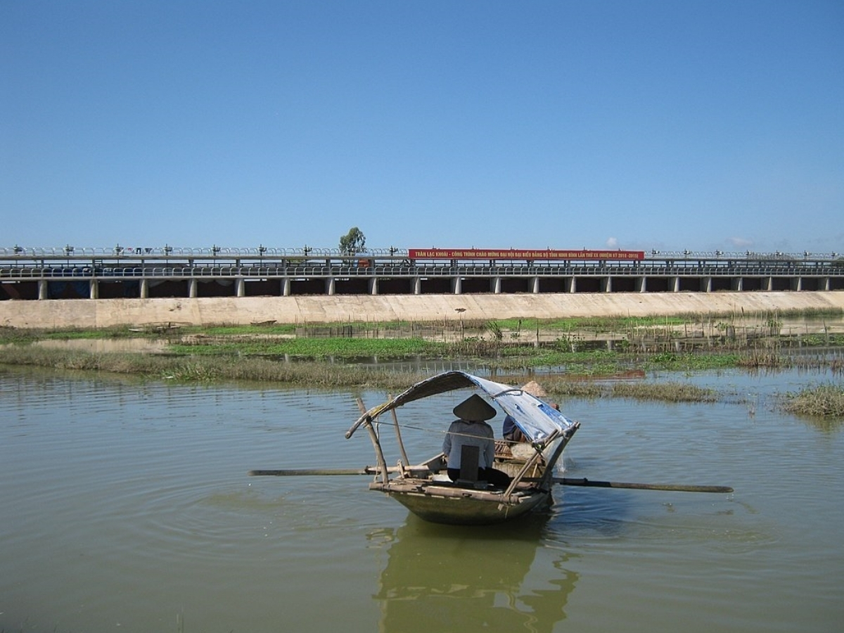Cư dân ven bờ sông Hoàng Long chèo thuyền nhỏ và thả lưới bắt cá.