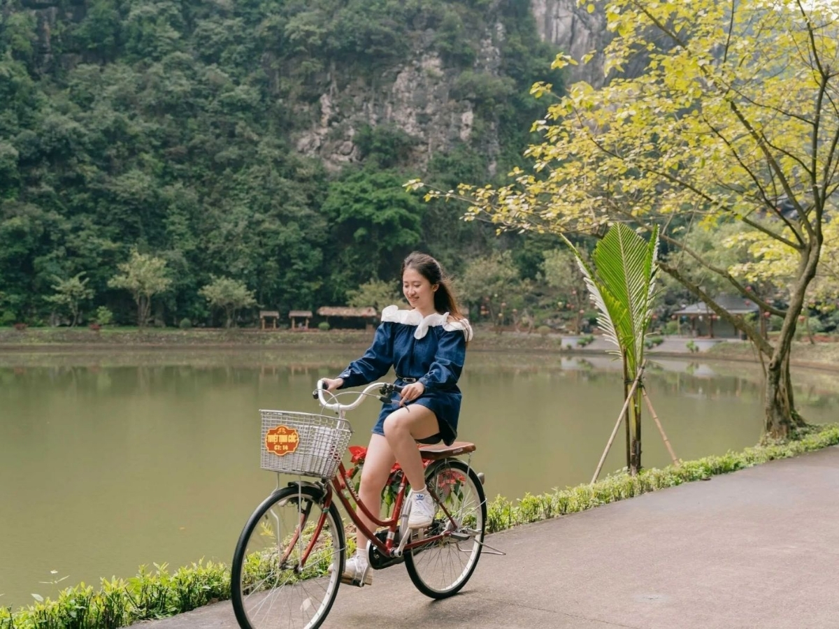 Du khách mặc trang phục thoải mái đạp xe ven hồ, tận hưởng không gian yên bình.