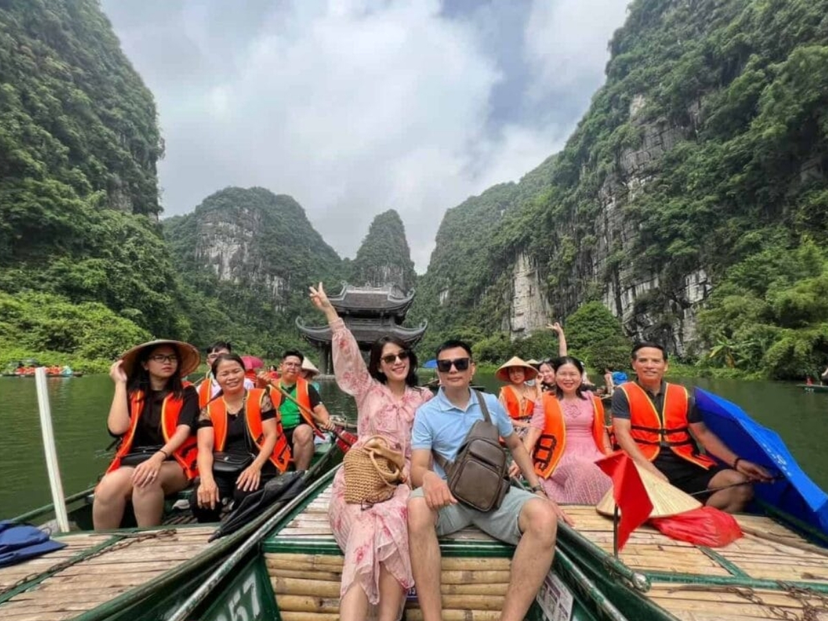 Du khách ngồi thuyền và háo hức tham quan danh thắng Tràng An.