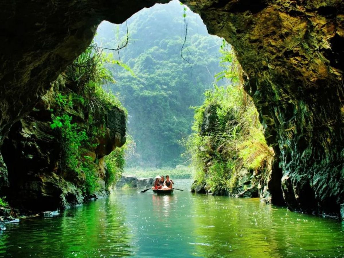 Du khách ngồi thuyền khám phá hang Địa Linh Tràng An.