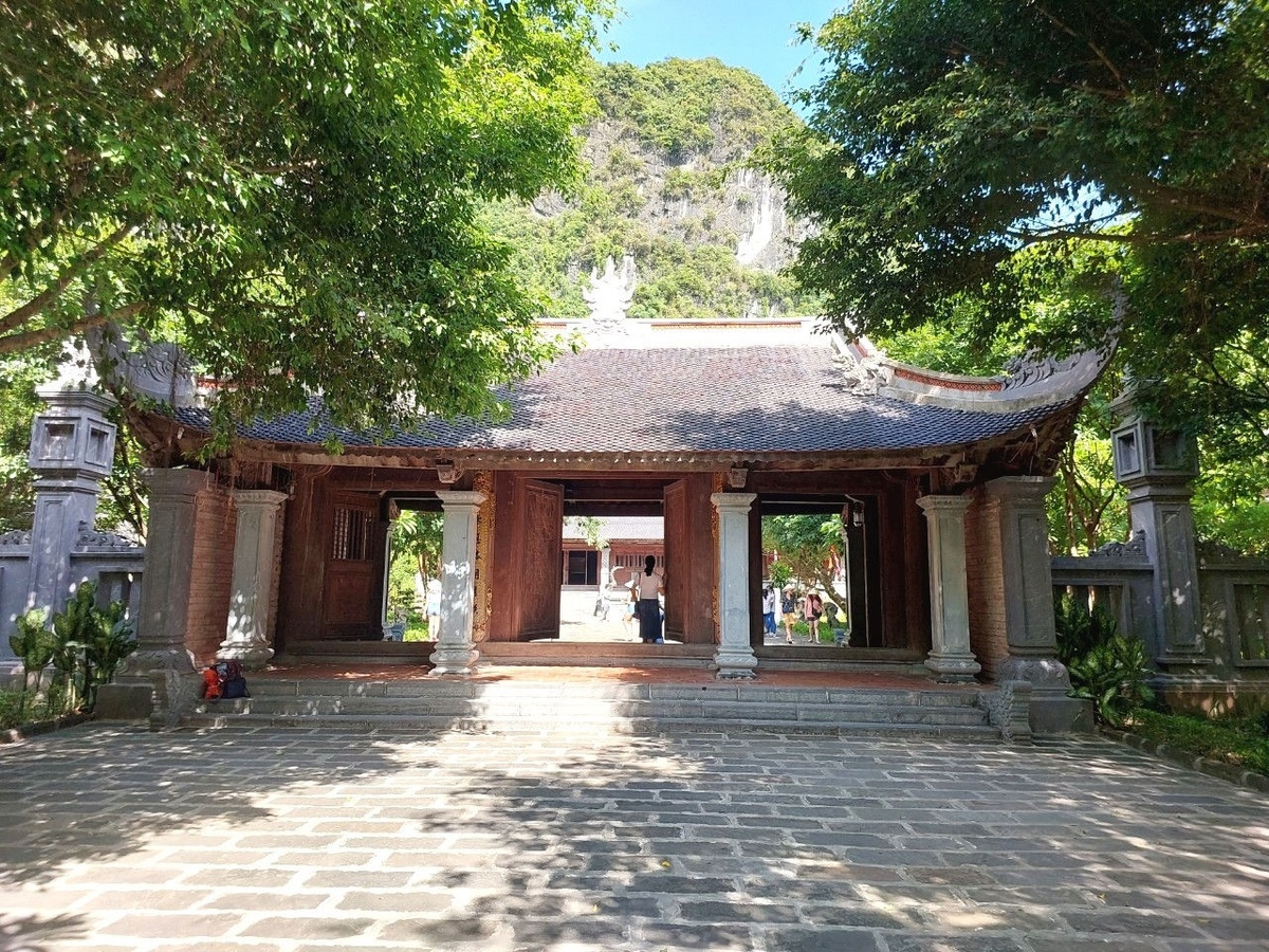 Cổng đền, sân đá và núi xanh tạo bối cảnh trang nghiêm tại điểm dừng tâm linh Tràng An. (Nguồn: Sưu tầm)