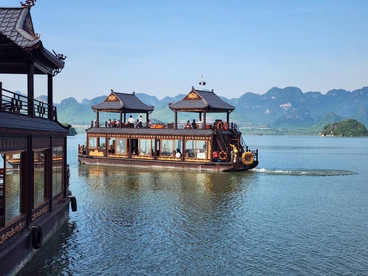 Du thuyền trên hồ Tam Chúc mở ra phông nền rộng với mặt nước, núi đá và các đảo nhỏ. (Nguồn: Sưu tầm)