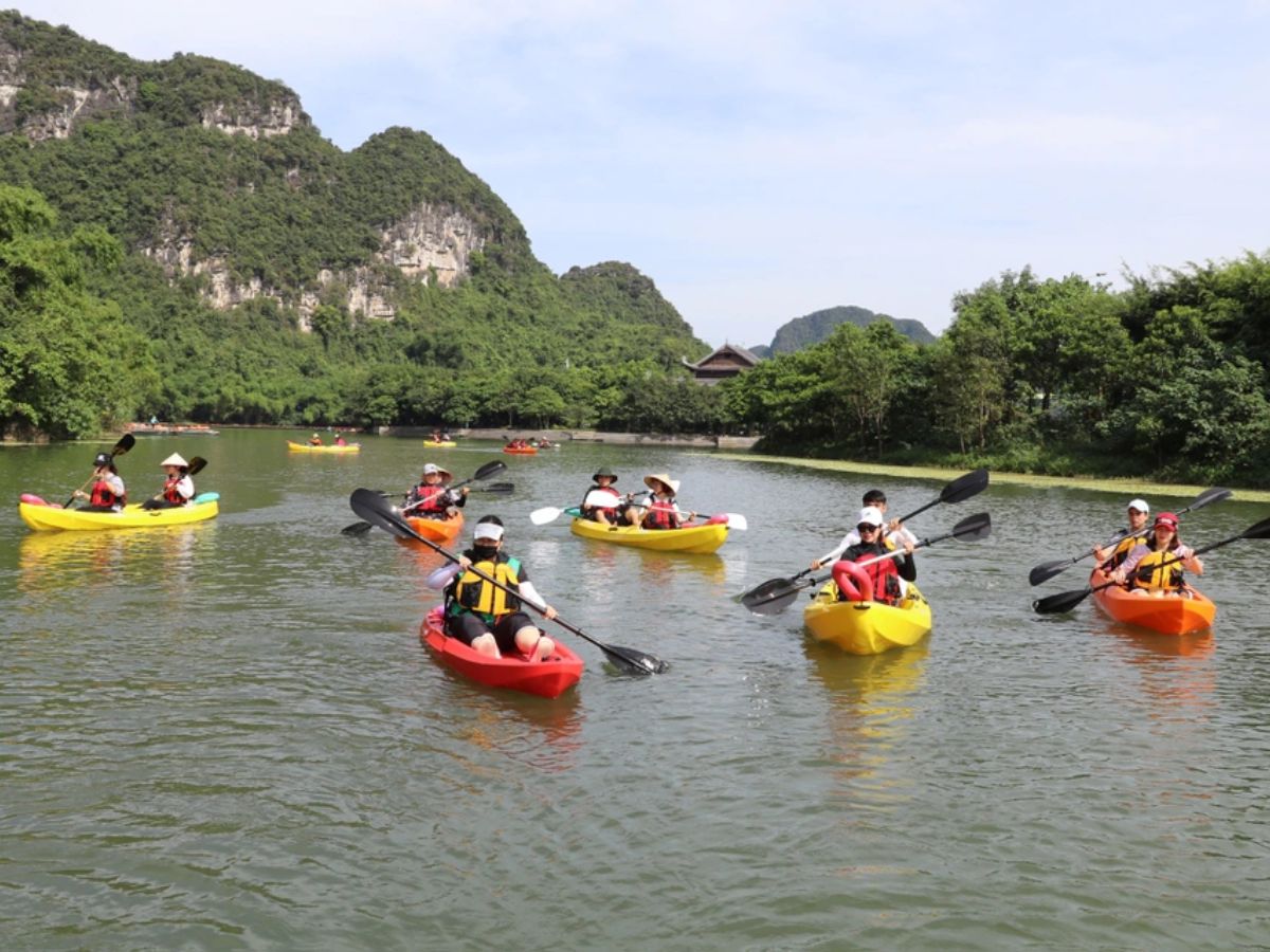 Du khách ngồi thuyền khám phá cảnh quan Tràng An trong tiết trời mùa thu. (Nguồn: Sưu tầm).