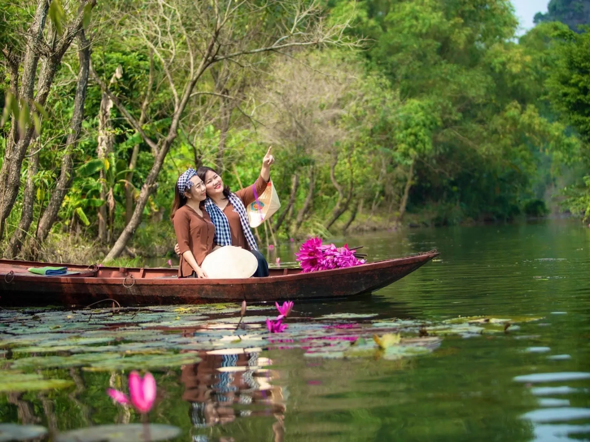 Du khách ngồi thuyền tham quan Thung Nắng.