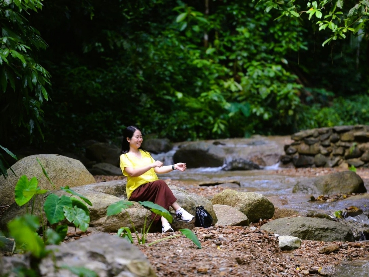 Du khách ngồi nghỉ bên bờ suối check-in và tận hưởng không gian yên tĩnh.